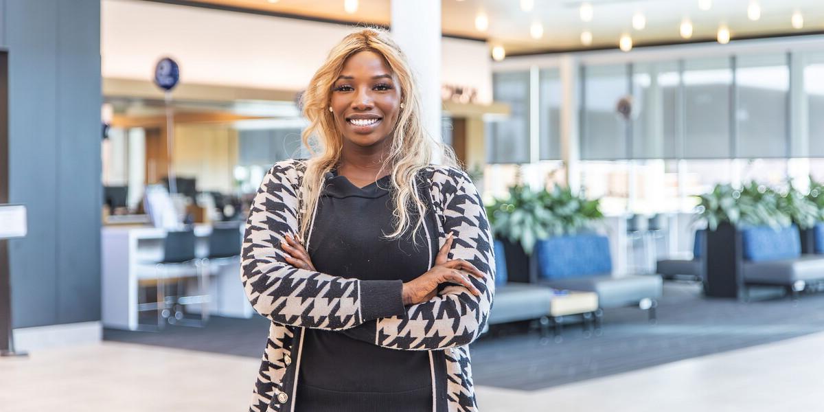 Portrait of a woman standing in a building lobby.